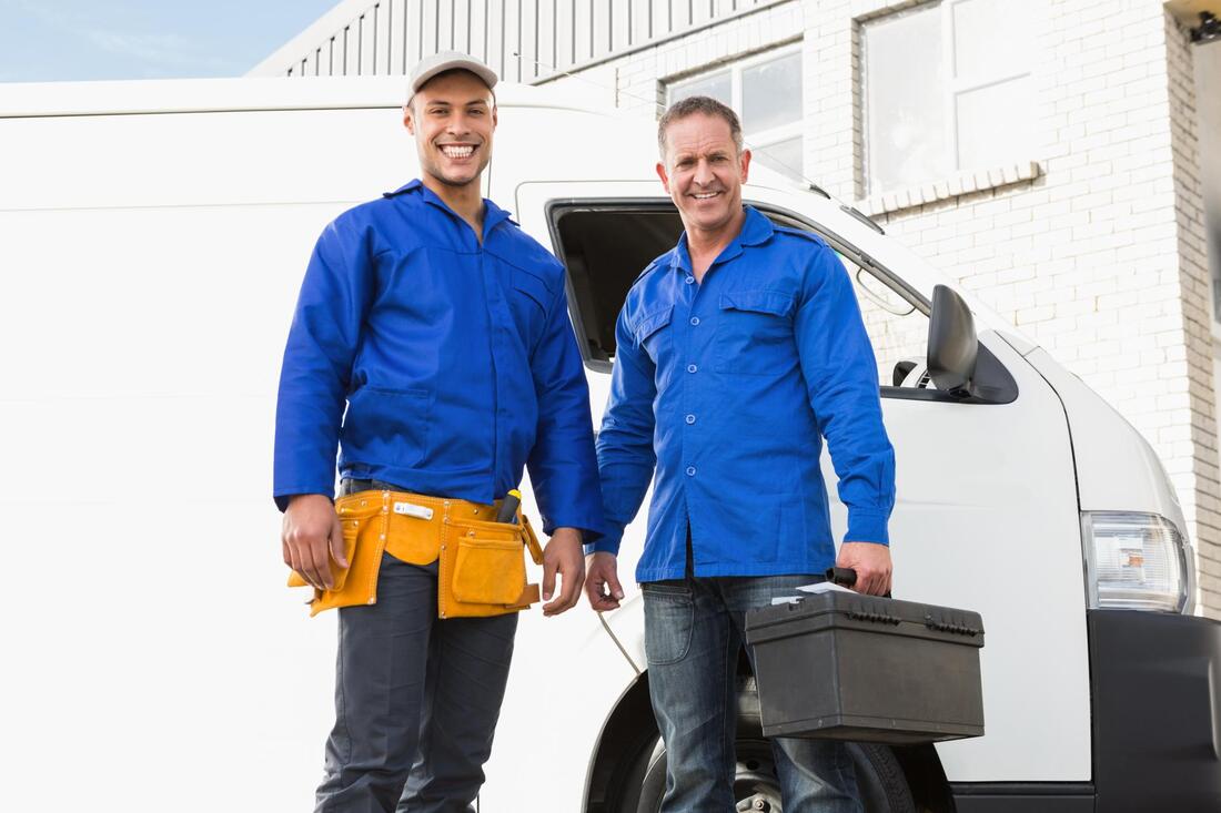 HVAC repairman posing next to their van